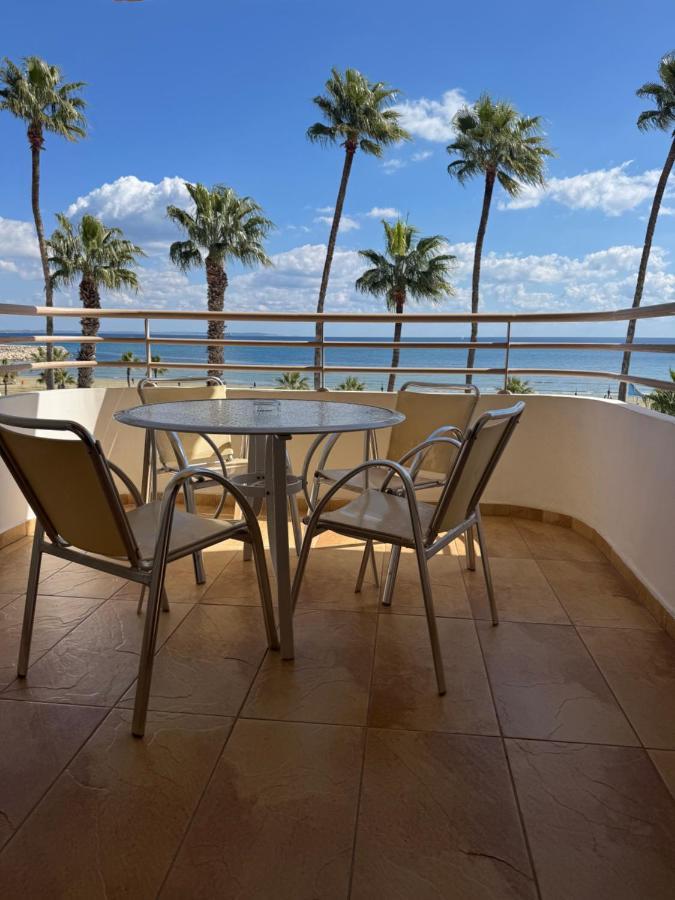 a table and chairs on a balcony with palm trees at Ithaki Phinikoudes Apartment No. 201 in Larnaka