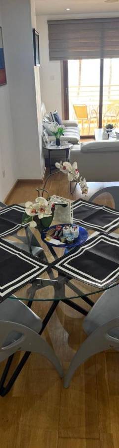 a table and chairs in a living room at Ithaki Phinikoudes Apartment No. 201 in Larnaka
