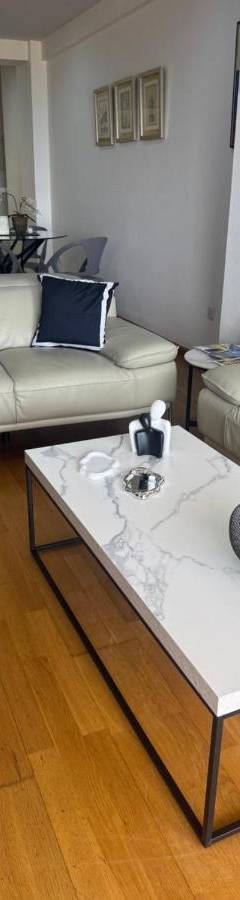 a living room with couches and a bowl of fruit on a table at Ithaki Phinikoudes Apartment No. 201 in Larnaka