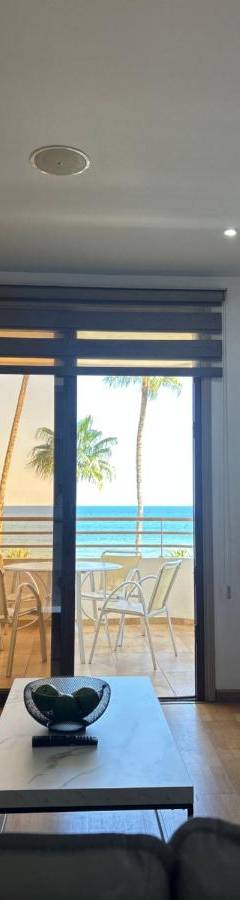 a living room with a couch and a view of the ocean at Ithaki Phinikoudes Apartment No. 201 in Larnaka
