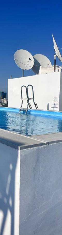 a pool with two chairs on top of a roof at Alex Residence in Larnaka