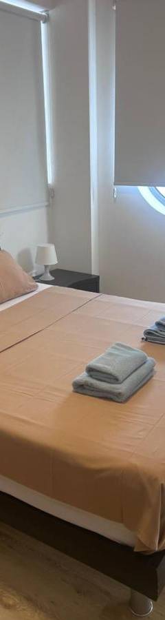 a bedroom with a large bed with two towels on it at Alex Residence in Larnaka
