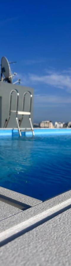 a swimming pool with two chairs in the water at Alex Residence in Larnaka