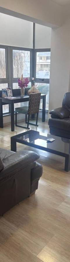 a living room with a couch and a tv and a table at Alex Residence in Larnaka