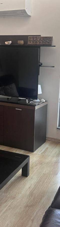 a living room with a couch and a large tv at Alex Residence in Larnaka