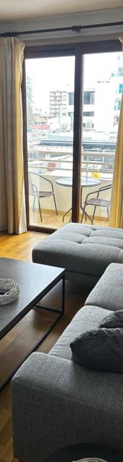 a living room with a couch and a coffee table at Ithaki Phinikoudes Apartment No. 204 in Larnaka