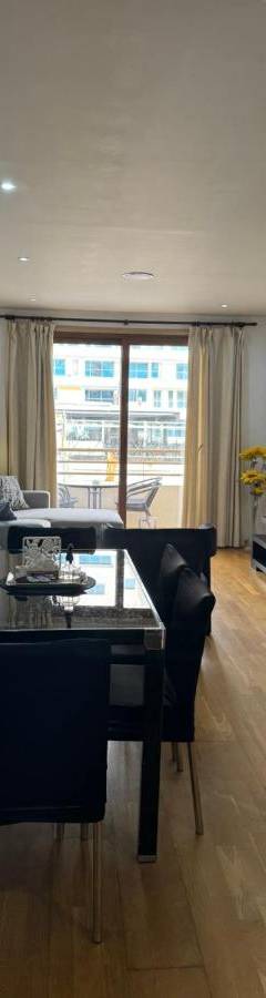 a dining room and living room with a table and chairs at Ithaki Phinikoudes Apartment No. 105 in Larnaka