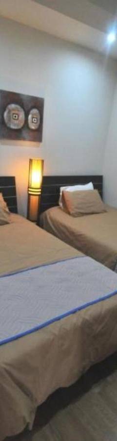 two beds in a room with two lamps on them at Ithaki Phinikoudes Apartment No. 105 in Larnaka