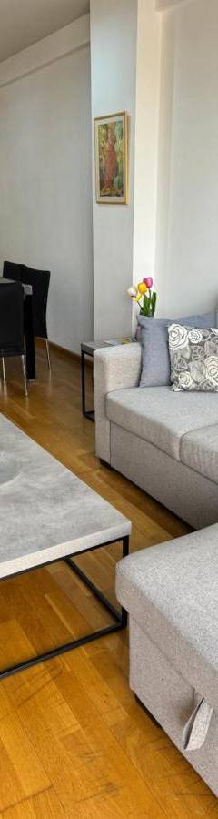 a living room with a couch and a table at Ithaki Phinikoudes Apartment No. 105 in Larnaka