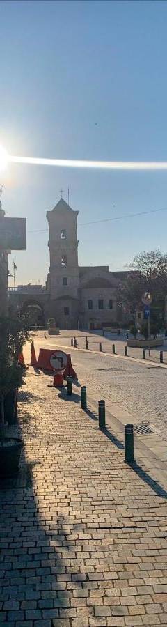 a cobblestone street with the sun shining on a building at Ithaki Phinikoudes Apartment No. 105 in Larnaka