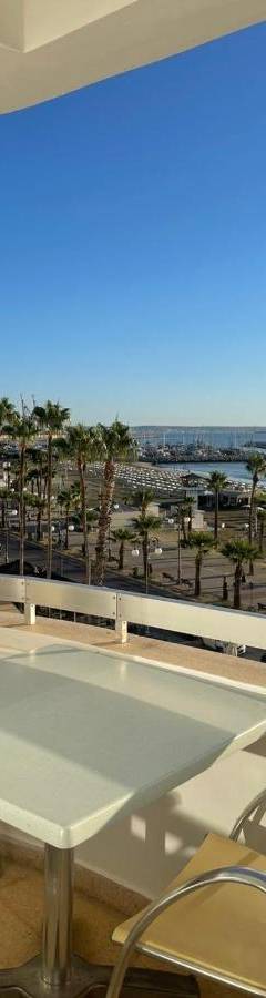 a table and chairs on a balcony with a view of the beach at Alex Beach Apartment 34 in Larnaka