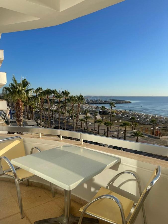 a table and chairs on a balcony with a view of the beach at Alex Beach Apartment 34 in Larnaka