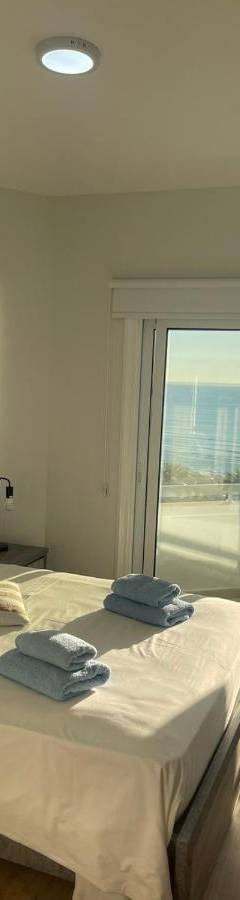 a bedroom with a bed with a view of the ocean at Alex Beach Apartment 34 in Larnaka