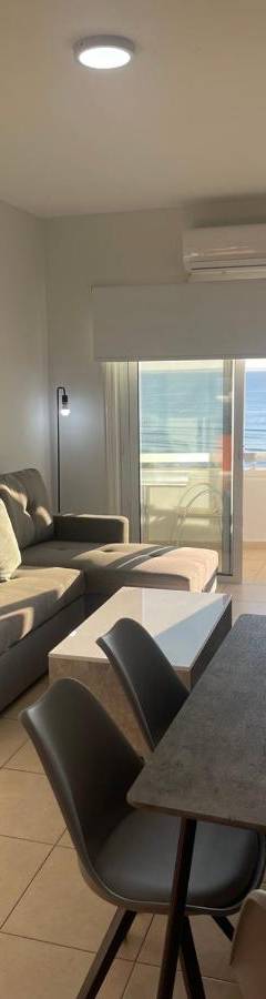 a living room with a couch and a table with chairs at Alex Beach Apartment 34 in Larnaka