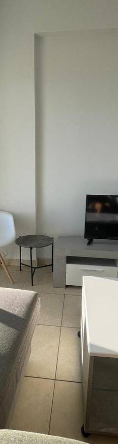 a living room with a couch and a tv at Alex Beach Apartment 34 in Larnaka
