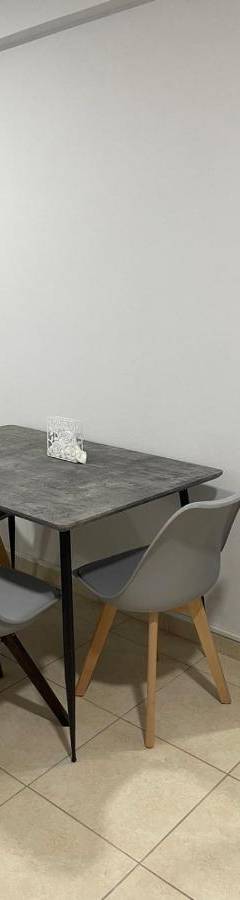 a dining room table with chairs and a mirror at Alex Beach Apartment 34 in Larnaka
