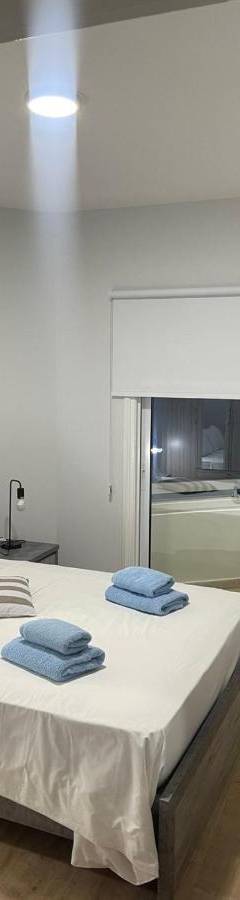 a bedroom with a bed with two towels on it at Alex Beach Apartment 34 in Larnaka