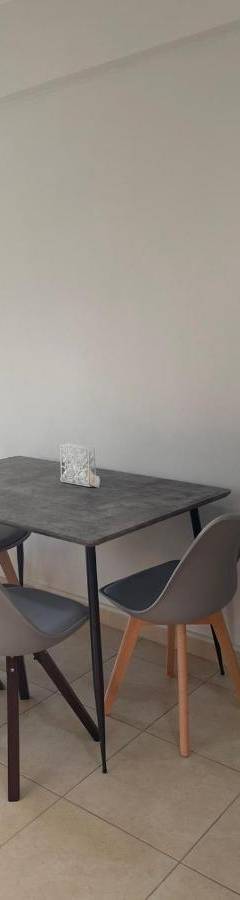 a dining room table with chairs and a mirror at Alex Beach Apartment 34 in Larnaka