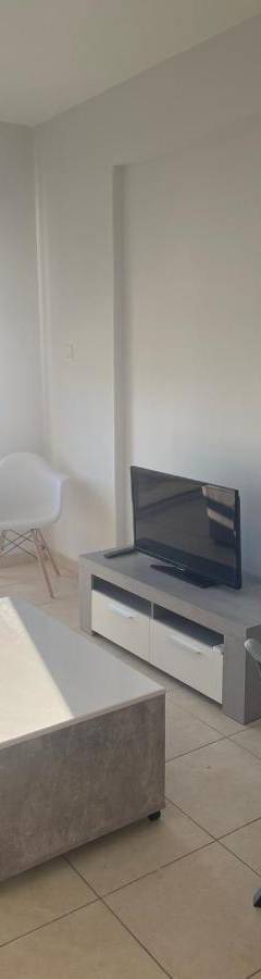 a living room with a couch and a tv at Alex Beach Apartment 34 in Larnaka