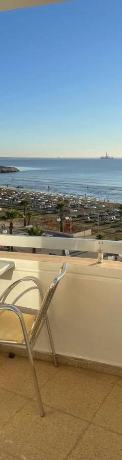 a chair sitting on a balcony with a view of the ocean at Alex Beach Apartment 34 in Larnaka