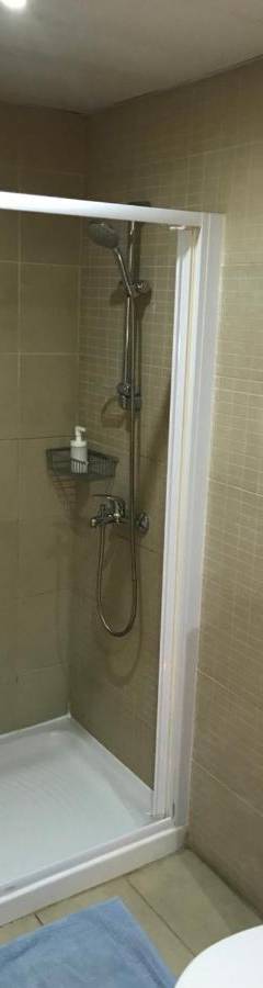 a bathroom with a shower with a shower curtain at Ithaki Phinikoudes Apartment No. 107 in Larnaka