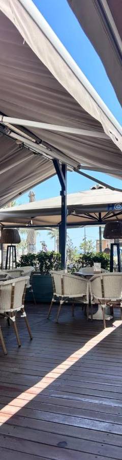 a patio with tables and chairs under a canopy at Ithaki Phinikoudes Apartment No. 107 in Larnaka