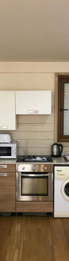 a kitchen with a stove and a white refrigerator at Ithaki Phinikoudes Apartment No. 107 in Larnaka