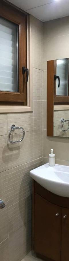 a bathroom with a sink and a mirror at Ithaki Phinikoudes Apartment No. 107 in Larnaka