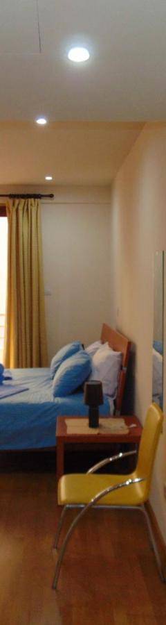 a bedroom with a blue bed and a window at Ithaki Phinikoudes Apartment No. 107 in Larnaka