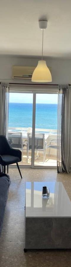 a living room with a couch and a view of the ocean at Alex Beach Apartment 51 in Larnaka