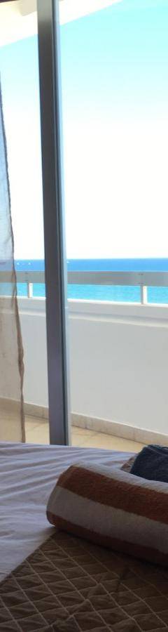 a bed with a window with a view of the ocean at Alex Beach Apartment 51 in Larnaka
