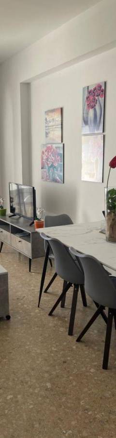a living room with a white table and chairs at Alex Beach Apartment 51 in Larnaka