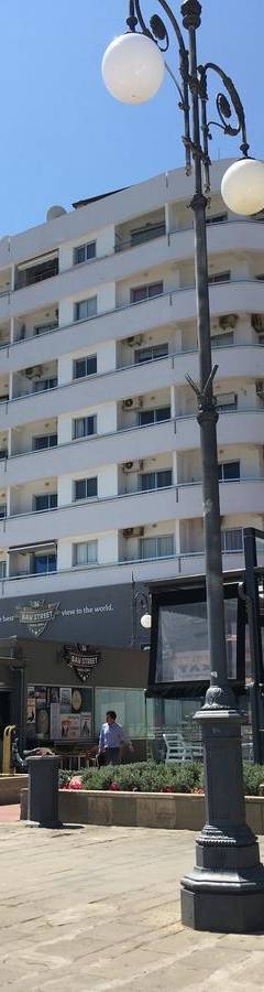a street light in front of a large building at Alex Beach Apartment 51 in Larnaka