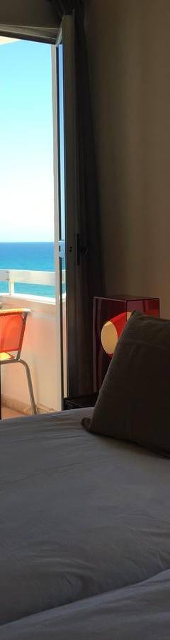 a bedroom with a bed with a view of the ocean at Alex Beach Apartment 51 in Larnaka