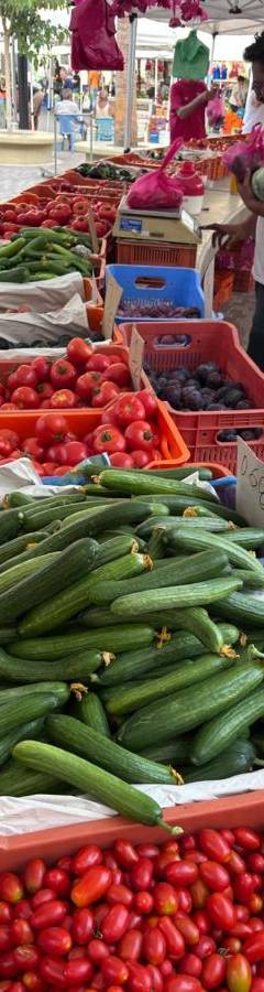 a display of tomatoes and cucumbers at a farmers market at Alex Beach Apartment 51 in Larnaka