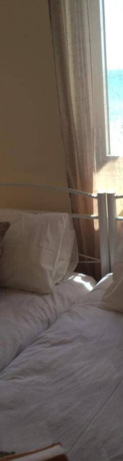 a bedroom with a bed with white sheets and pillows at Alex Beach Apartment 51 in Larnaka