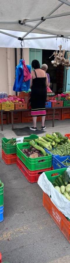 a market with many baskets of vegetables and people standing around at Alex Beach Apartment 51 in Larnaka