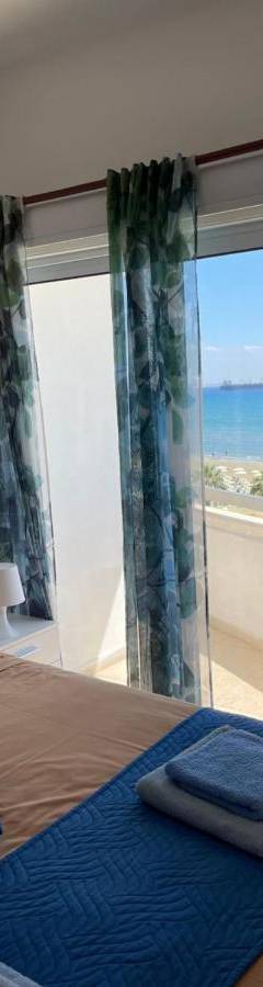 a bedroom with a bed with a view of the ocean at Alex Beach Apartment 31 in Larnaka