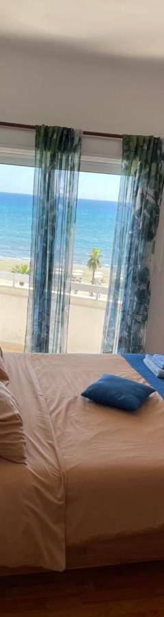 a bedroom with a bed with a view of the beach at Alex Beach Apartment 31 in Larnaka