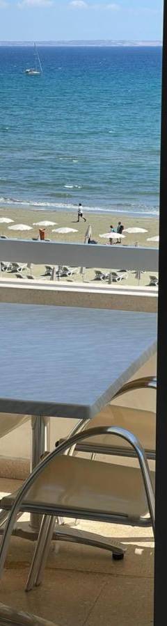 a table and chairs with a view of the beach at Alex Beach Apartment 31 in Larnaka