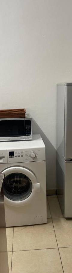 a kitchen with a refrigerator and a washing machine at Alex Beach Apartment 31 in Larnaka