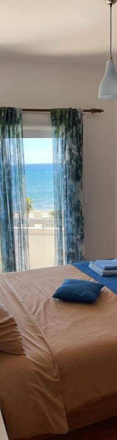 a bedroom with a bed with a view of the beach at Alex Beach Apartment 31 in Larnaka
