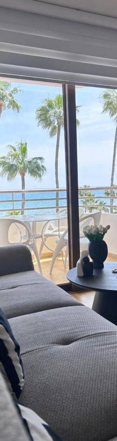 a living room with a couch and a view of the ocean at Ithaki Phinikoudes Apartment No. 202 in Larnaka