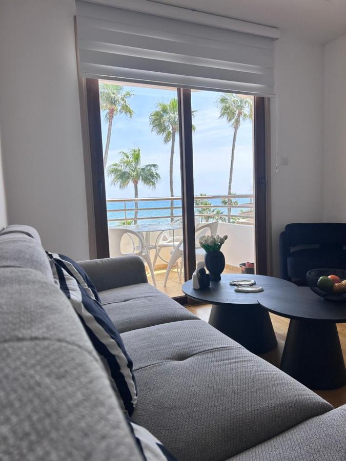 a living room with a couch and a view of the ocean at Ithaki Phinikoudes Apartment No. 202 in Larnaka