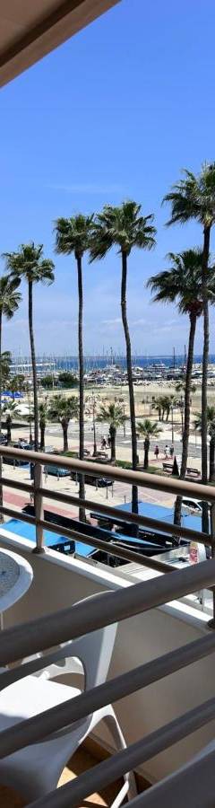 a balcony with a view of the beach and palm trees at Ithaki Phinikoudes Apartment No. 202 in Larnaka