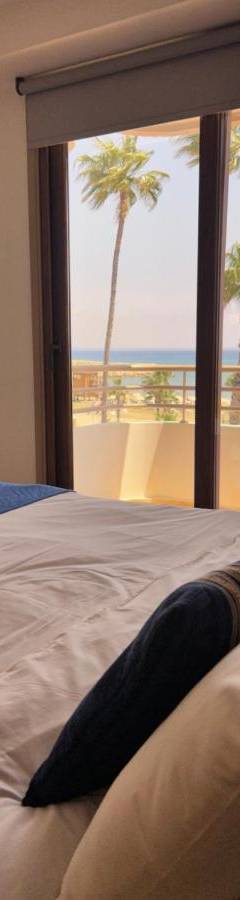 a bedroom with a bed with a view of the beach at Ithaki Phinikoudes Apartment No. 202 in Larnaka