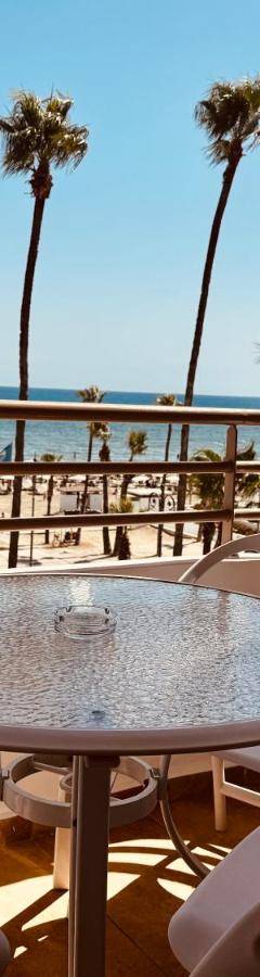 a table and chairs on a balcony overlooking the beach at Ithaki Phinikoudes Apartment No. 202 in Larnaka