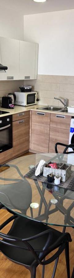 a kitchen with a glass table and black chairs at Ithaki Phinikoudes Apartment No. 202 in Larnaka