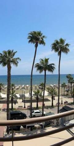a view of the beach from a building with palm trees at Ithaki Phinikoudes Apartment No. 202 in Larnaka
