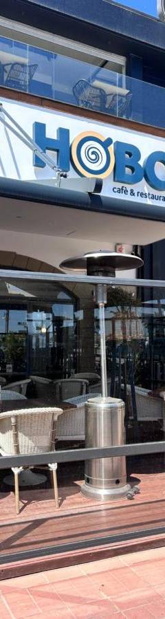 a restaurant with tables and chairs in a building at Ithaki Phinikoudes Apartment No. 202 in Larnaka